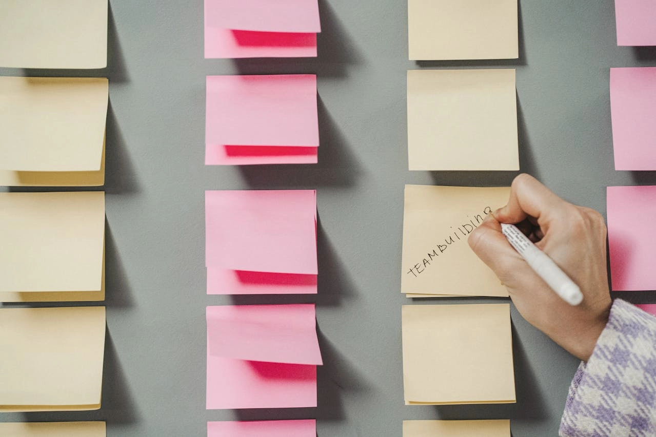 Main écrivant sur des post-its lors d'un atelier de cadrage — accompagnement mutuelles de proximité